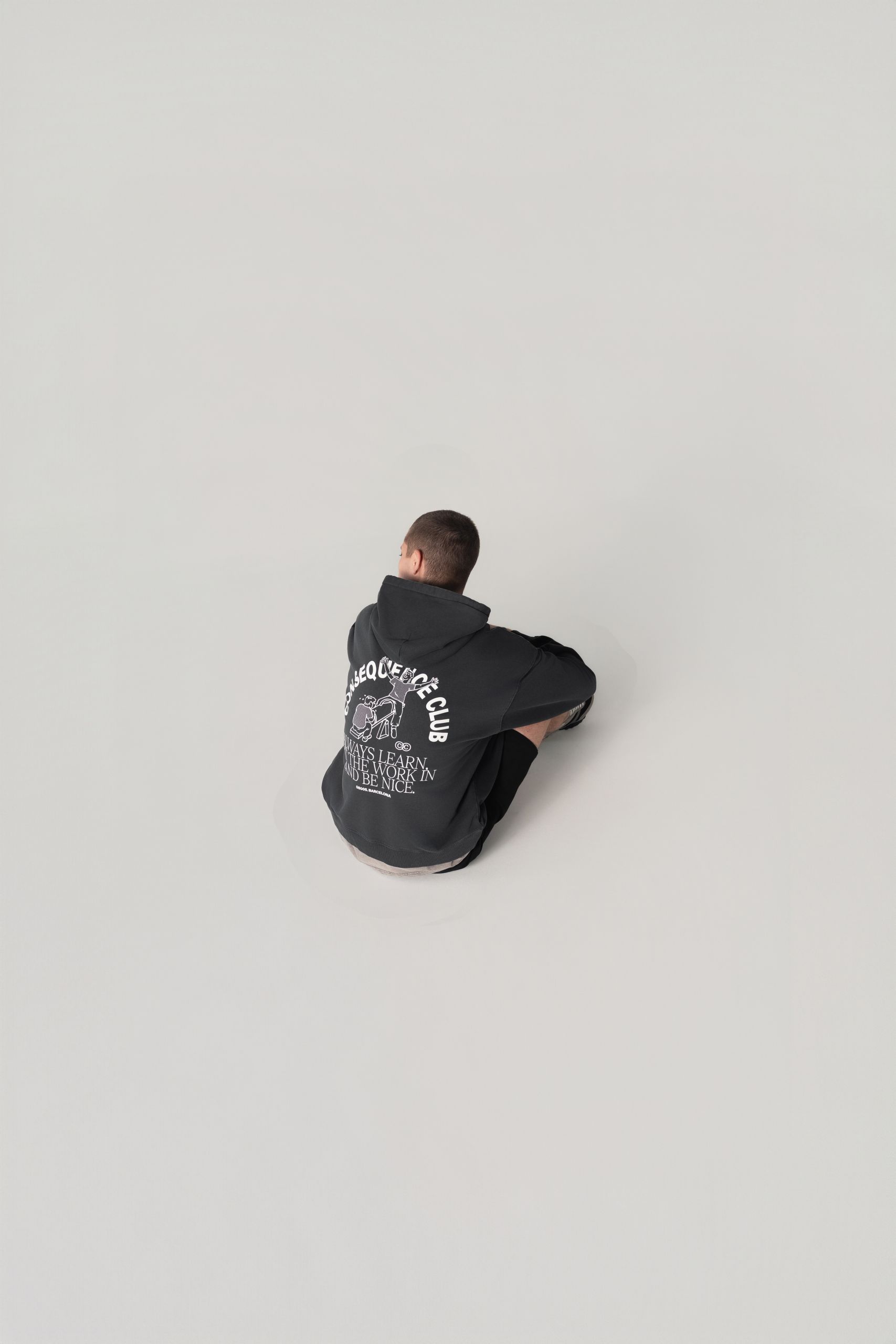 Model sitting wearing oversized hoodie